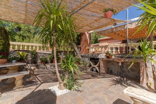 een terras met palmbomen en een bar bij Casa Rural Rizao in Nigüelas