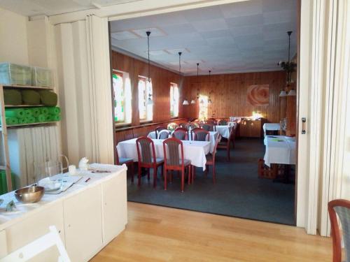 a dining room with white tables and red chairs at Haus Gaia in Frauenstein