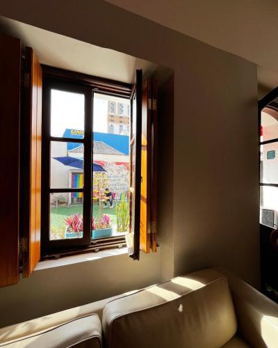 a living room with a couch and a window at Hostel Matilda in Curitiba