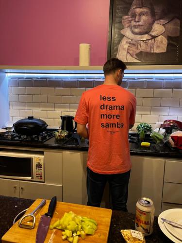 a man is standing in a kitchen at Hostel Matilda in Curitiba