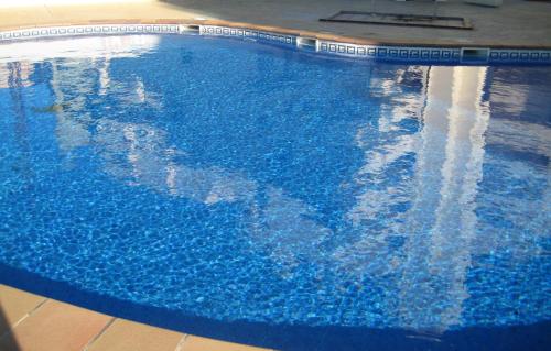 ein großer blauer Pool mit blauem Wasser in der Unterkunft Ada Neptuno Apartamento, Aire acondicionado, WiFi, Piscinas, Parking in Peñíscola