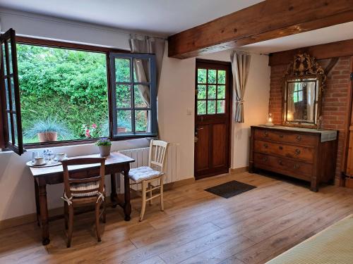 d'une salle à manger avec une table, des chaises et une fenêtre. dans l'établissement Le Bois d'Albran, à La Calotterie