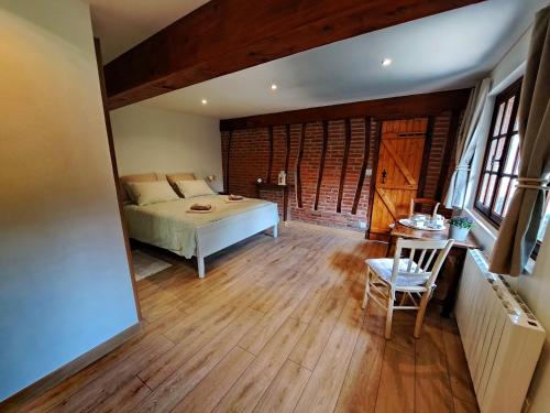 Schlafzimmer mit einem Bett und Holzboden in der Unterkunft Le Bois d'Albran in La Calotterie