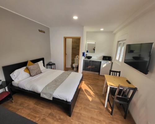 a bedroom with a bed and a table and a television at Guesthouse of Alcobaça in Alcobaça