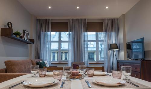 a dining room table with plates and glasses on it at Friends and Family Vacation Apartments in Rīga
