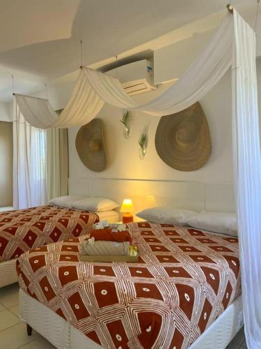 a bedroom with a large bed with a canopy at Casa de praia no Flamengo in Salvador