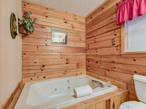 baño con bañera y paredes de madera en Mountain Mist, 2 Bedrooms, Sleeps 6, Pool Table, Pet Friendly, Indoor Pool en Sevierville