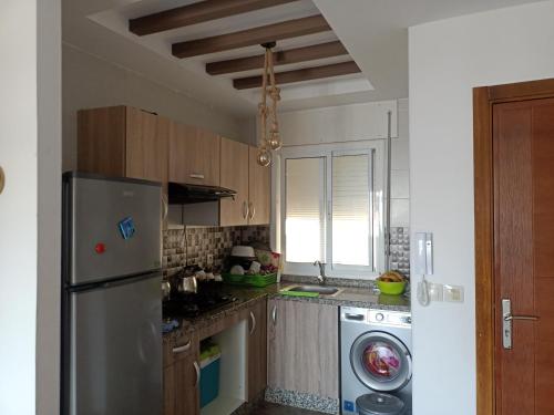 a kitchen with a refrigerator and a washing machine at برج مكاد in Oued Laou