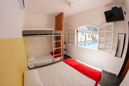 a room with two bunk beds and a tv at Villa Salgada Maresias in Maresias
