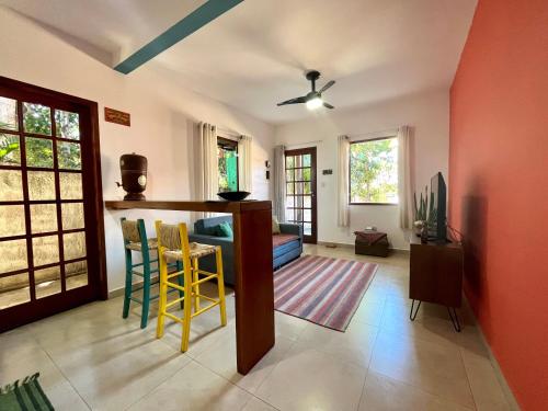 una sala de estar con paredes de color naranja y sillas amarillas. en Apartamento Chapada Diamantina en Lençóis