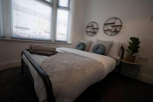 - une chambre avec un grand lit et deux miroirs sur le mur dans l'établissement Abingdon House Workstays UK, à Middlesbrough