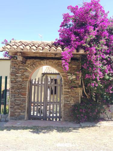una puerta con flores púrpuras delante de una casa en Il Casale Del Cortonese, en Sassari
