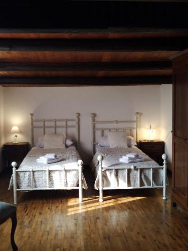 2 camas en una habitación con suelo de madera en Il Casale Del Cortonese, en Sassari