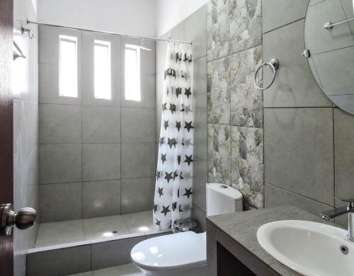 Casa Hotel Mamaluna في لوناهوانا: حمام مع مرحاض ومغسلة ودش