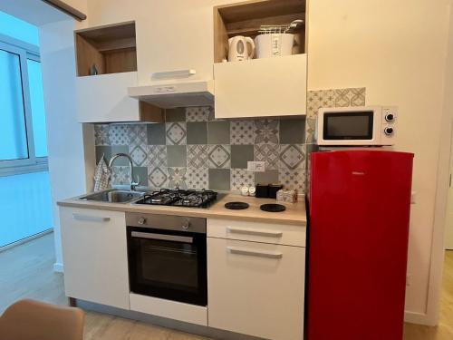 eine Küche mit einem roten Kühlschrank und einer Mikrowelle in der Unterkunft La casa di Toto smart in Neapel