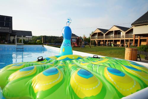 un tobogán de agua inflable en una piscina en Resort Mielenko, en Mielenko