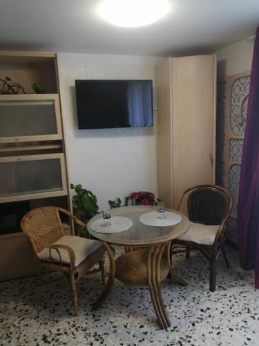une chambre avec une table, deux chaises et une télévision dans l'établissement Magnifique Studio non fumeur près de la gare, à Béziers