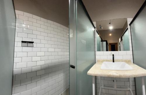 La salle de bains est pourvue d'un lavabo et d'un miroir. dans l'établissement Hostel Matilda, à Curitiba