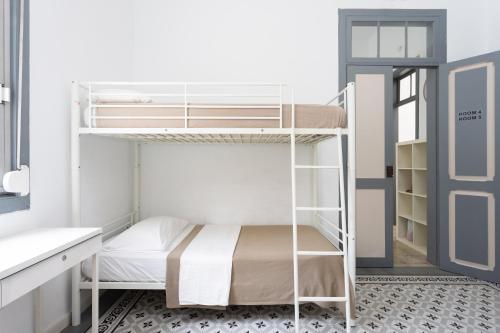 Łóżko piętrowe w niewielkim pokoju z drzwiami w obiekcie Wanderlust Hostel w mieście Santa Cruz de Tenerife