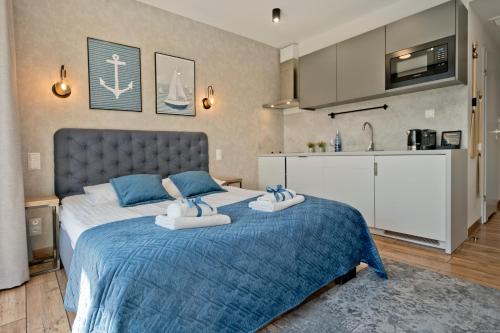 a bedroom with a bed with two towels on it at Aparthotel Anchoria BlueApart in Mechelinki