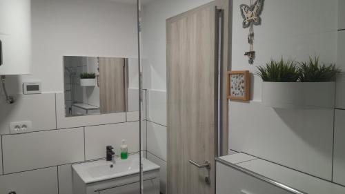 Baño blanco con lavabo y espejo en Apartma Ana, en Koper
