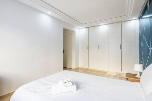 a white bedroom with a white bed and white cabinets at TT Holidays Hassan Tower 3Bedrooms in Rabat