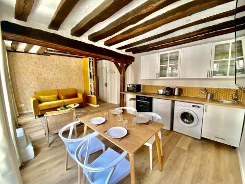 cocina con mesa y sillas en una habitación en Le Mimosa, en Rouen