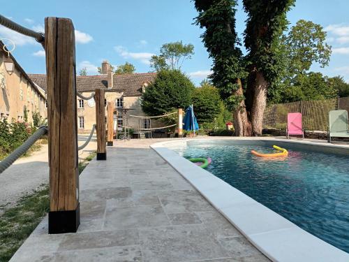 una piscina con tobogán y un parque infantil en La Maison des Maîtres de Forge en Moloy