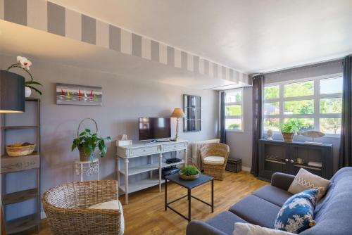 a living room with a couch and a desk at Abri du Pêcheur in La Forêt-Fouesnant