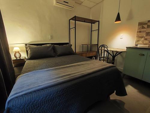 Un dormitorio con una cama y una mesa con una mesa. en VILLA BILAC 10 - Studio próximo à Vila Germânica Bairro da Velha, en Blumenau