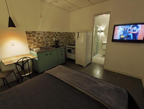 uma cozinha com uma cama e uma televisão na parede em VILLA BILAC 10 - Studio próximo à Vila Germânica Bairro da Velha em Blumenau