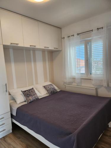 um quarto com uma cama grande e armários brancos em Apartman Šime em Pakoštane