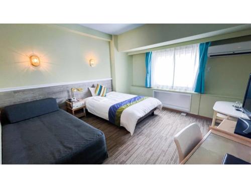a hotel room with a bed and a couch at Hotel AreaOne Sakaiminato Marina - Vacation STAY 81682v in Sakaiminato