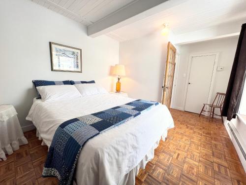 a bedroom with a bed with a blue and white blanket at Chalets Montmorency Mont-Sainte-Anne in Saint-Férréol-les-Neiges