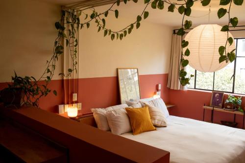 a bedroom with a white bed with orange walls at Hotel San Fernando in Mexico City