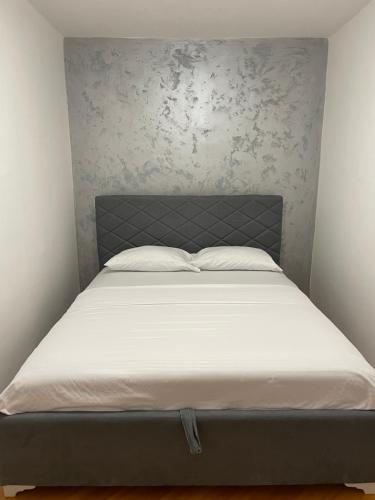 Ce lit se trouve dans une chambre dotée d'un matelas blanc. dans l'établissement Apartments City View, à Igalo
