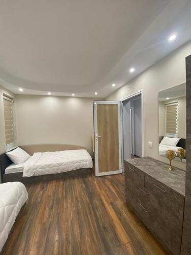 a large room with two beds and a mirror at Апартамент в Сарафово in Burgas City