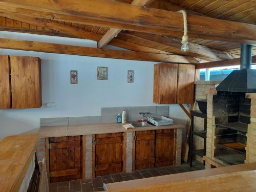 a kitchen with wooden cabinets and a stove at Börzsöny Aranya Vendégház in Nagybörzsöny