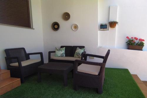 sala de estar con 2 sillas y sofá en Casita Barrena, en Bueu