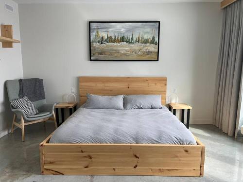 a bedroom with a wooden bed and a chair at L'Auguste - Luxe et confort in Petite-Rivière-Saint-François