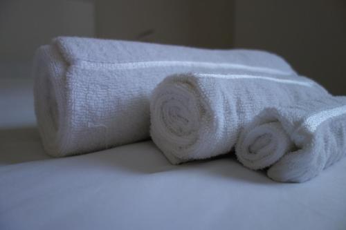 a stack of towels sitting on top of a bed at La CASA di LUCA-Fiera e Stazione-Private Parking in Bologna