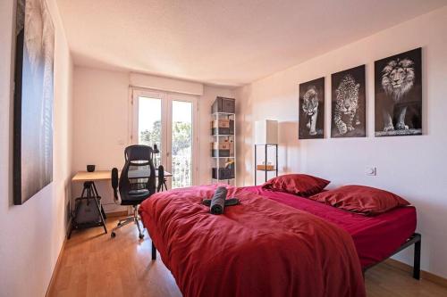 een slaapkamer met een bed met een rode deken en een bureau bij *Appt Rue Tour Gayraud, 4 Pers, Parking, Wi-Fi* in Montpellier