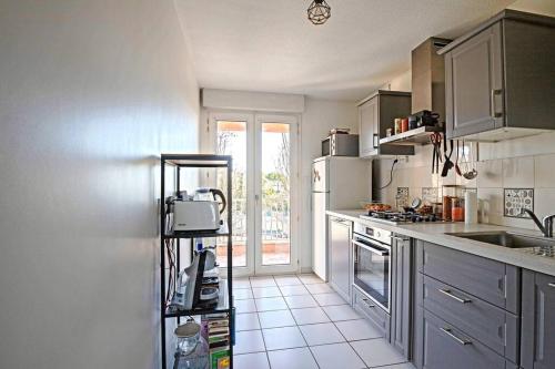 cocina con fregadero y fogones horno superior en *Appt Rue Tour Gayraud, 4 Pers, Parking, Wi-Fi* en Montpellier