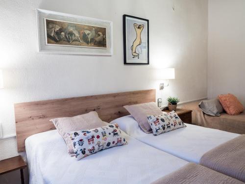 1 dormitorio con 2 camas y un cuadro en la pared en Acogedor apartamento entre montañas, en Sant Corneli de Cercs 