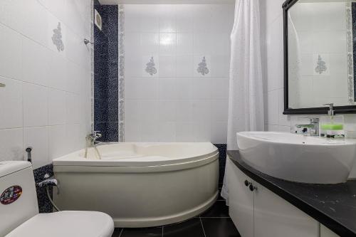 La salle de bains est pourvue d'une baignoire, d'un lavabo et de toilettes. dans l'établissement Naukova Street Appartamento, à Lviv