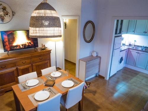 comedor con mesa, sillas y chimenea en Acogedor apartamento entre montañas, en Sant Corneli de Cercs 