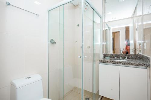 La salle de bains est pourvue d'une douche, de toilettes et d'un lavabo. dans l'établissement Flat Top - 100 M Da Praia De Pitangueiras 4083, à Guarujá