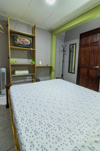 a bedroom with a bed and a wooden door at Delcafetalcr in San José