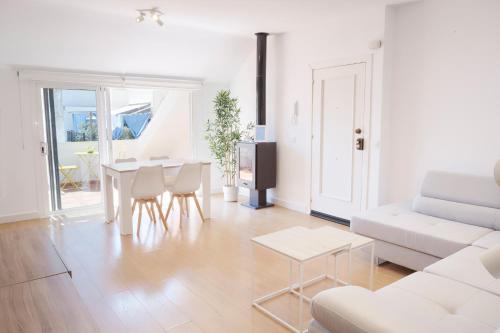 a white living room with a white couch and a table at City Center Penthouse with Solarium 2 minutes from the Beach in Fuengirola