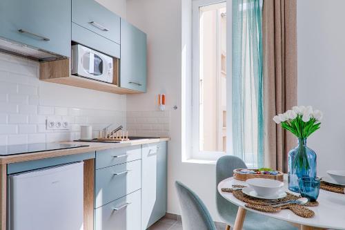 a kitchen with a table with a vase of flowers at La Bouverie in Romans-sur-Isère